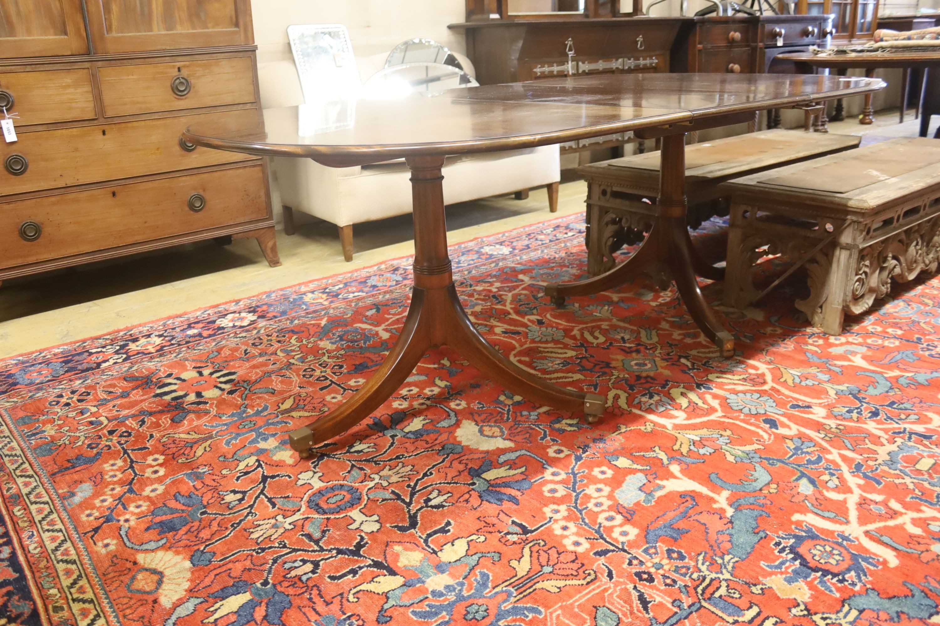 A William Tillman style reproduction mahogany twin pillar extending dining table, 186cm extended, (one spare leaf) width 106cm, height 73cm